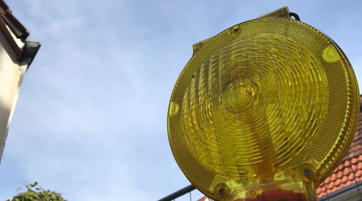 Baustellenlampe vor Zaun